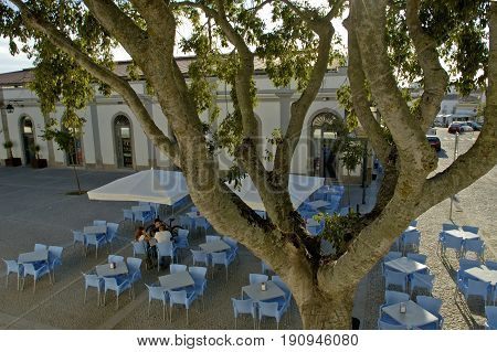 Evora, Alentejo, Portugal, 26-September-2007: Three youngsters sitting at a table on a colourful terrace in Evora.