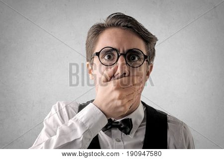 Spellbound man covering his mouth with his hand