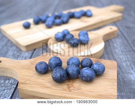 Ripe and fresh blueberries on bamboo cutting board.