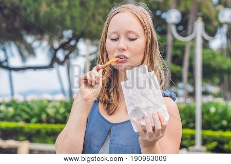 Women Eat Fried Sweet Potatoes In The Park. Junk Food Concept
