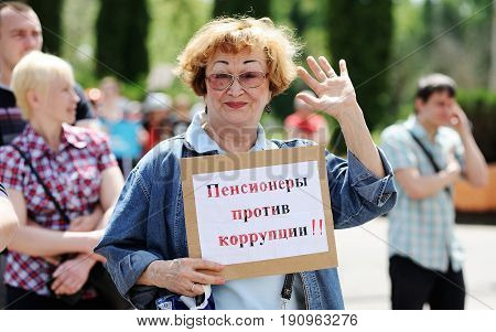 Orel Russia June 12 2017: Russia protests. Smiling senior woman with banner Pensioners against corruption saluting