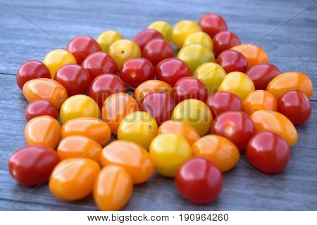 Ripe cherry tomatoes on a wooden background.