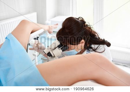 Professional gynecologist examining her female patient on a gynecological chair,