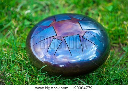 steel tongue drum, metal tongue drum, modern musical instrument on natural background