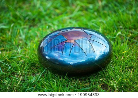steel tongue drum, metal tongue drum, modern musical instrument on natural background