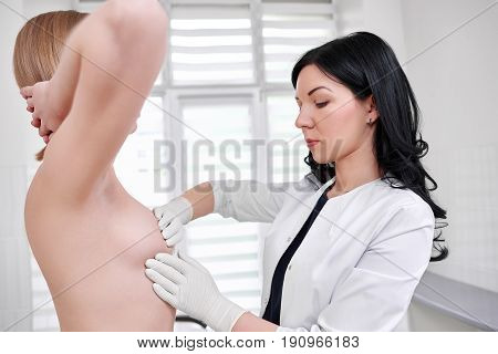 Young female doctor examining breast of her patient mammalogy cancer awareness checkup hospital clinic medicine people concept.