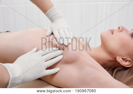 Cropped shot of a female doctor drawing lines on the breast of her female patient preparing for breast augmentation plastic surgery medicine concept.