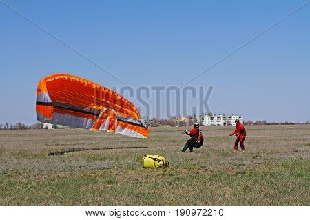 Volgograd Russia - April 20 2013: Assistant helps the paraglider to straighten the paraplane before the flight in Volgograd