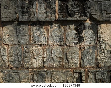 Stone carvings of skulls of sacrificed Mayan ball court players, Chichen Itza, Mexico.