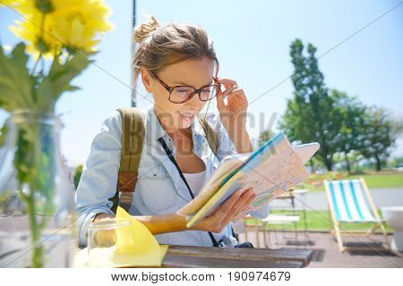 Globetrotter reading city map at coffee shop table