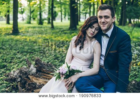 lovely cople sits in park on sunset
