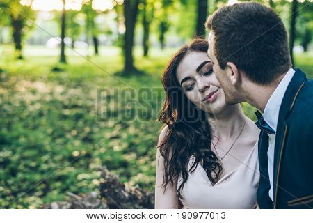 lovely cople sits in park on sunset