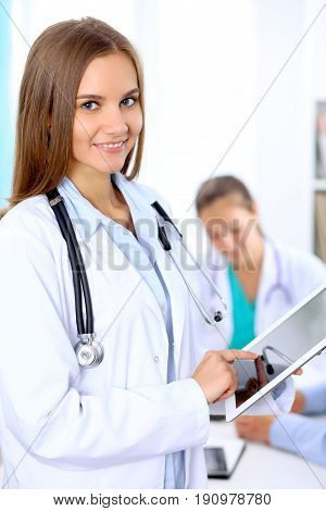 Happy doctor woman  with medical staff at the hospital sitting at the table and discussing medical history