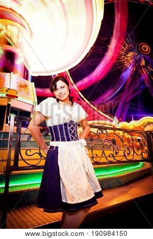 young woman standing next to brightly colored carousel