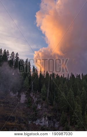 Sunset in the mountains highlights a rose colored cloud.