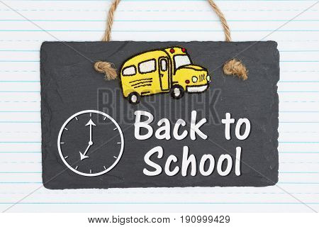 Back to School hand lettering text and school bus on weathered old chalkboard with retro lined paper