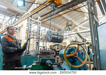 Turner Worker Manages The Metalworking Process Of Mechanical Cutting On A Lathe