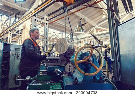 Turner Worker Manages The Metalworking Process Of Mechanical Cutting On A Lathe