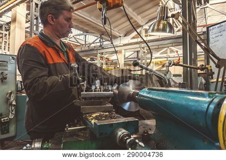 Turner Worker Manages The Metalworking Process Of Mechanical Cutting On A Lathe