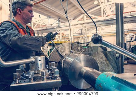 Turner Worker Manages The Metalworking Process Of Mechanical Cutting On A Lathe