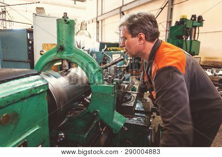 Turner Worker Manages The Metalworking Process Of Mechanical Cutting On A Lathe