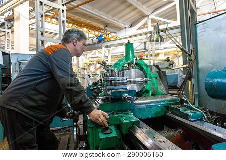 Turner Worker Manages The Metalworking Process Of Mechanical Cutting On A Lathe