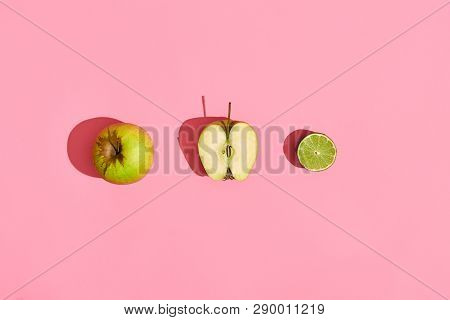Food Design. Composition Of Fresh Fruits, Green Apple, Half Of Green Apple And Lime On Pink Coral Ba
