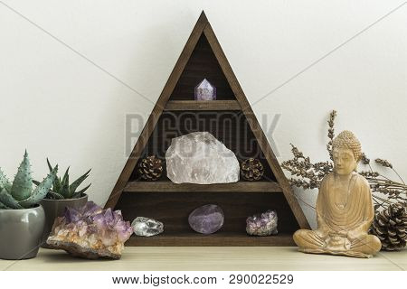 Triangular Wooden Crystal Shelf With Succulent Plants Foliage And Wooden Statue Of Buddha