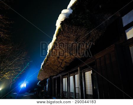 Japanese Gassho-style House With Thick Snow On The Steep Roof . Only One Source Of Light To The Hous