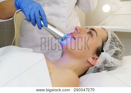 Hardware Cosmetology. Ultrasound Chromotherapy. Beautician Carries Out Procedure For Tightening Skin