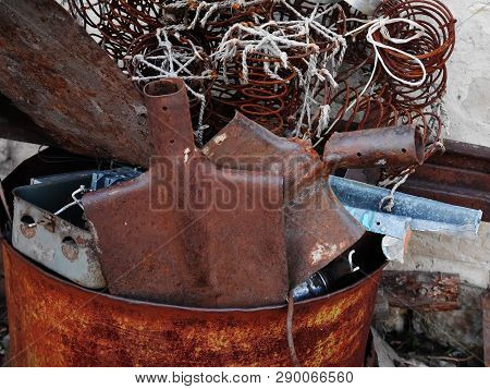 Rusty Shovel And Wire In A Rusty Barrel