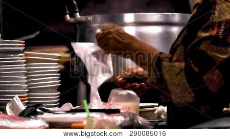 Blur Scooping Food From The Boiler To Put Bags For Customers
