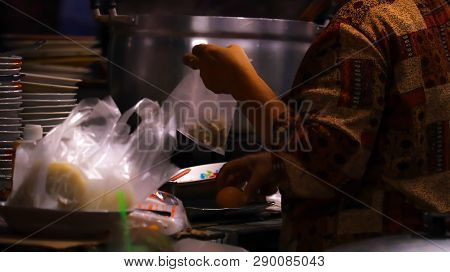 Blur Scooping Food From The Boiler To Put Bags For Customers