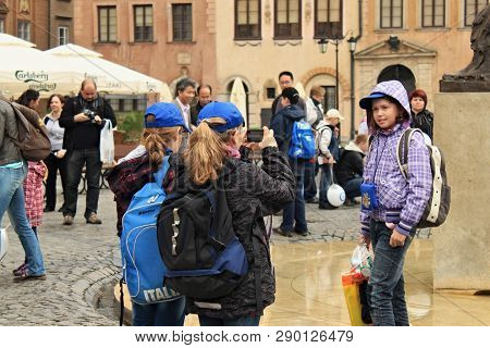 Warsaw, Poland - May 12, 2012: Unknown Tourists Take Pictures In The Warsaw Old Town Market Place (r