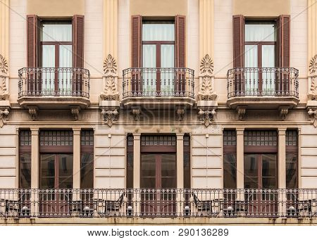 Several Windows And Balconies In A Row On The Facade Of The Urban Historic Building Front View, Barc