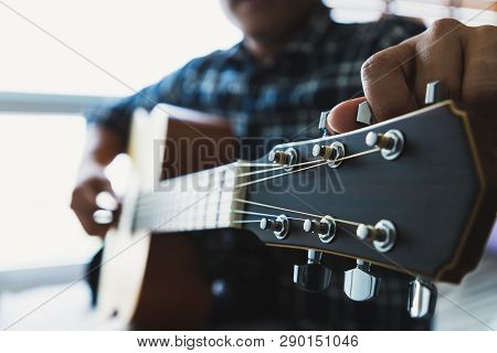Close Up Men Wearing Blue Plaid Shirts Are Setting The Guitar