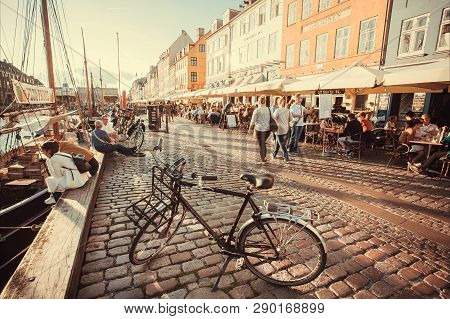 Copenhagen, Denmark - Sept 8: Evening Sun On Nyhavn Riverbank With Walking People, And Relaxing In R
