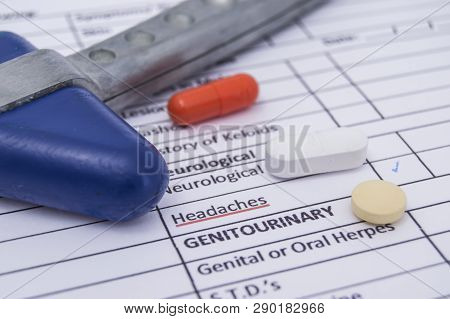 Neurological Reflex Hammer And Colored Tablets, Pills And Capsula Lies On A Sheet Of Health History 