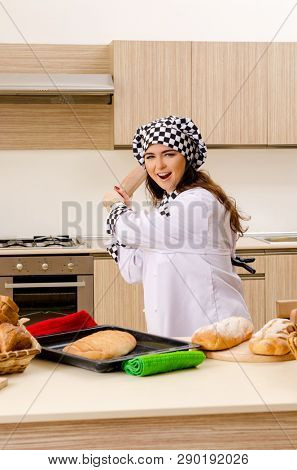 Young female baker working in kitchen 