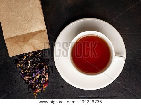 Elicious Tea In A White Mug, Scattered Tea From The Package On A Stone Background