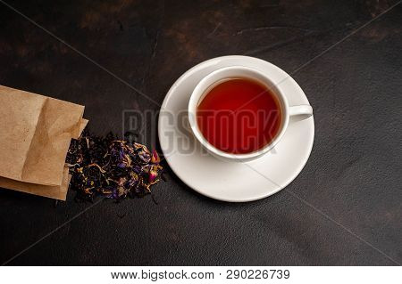 Elicious Tea In A White Mug, Scattered Tea From The Package On A Stone Background