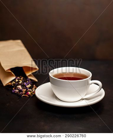 Elicious Tea In A White Mug, Scattered Tea From The Package On A Stone Background