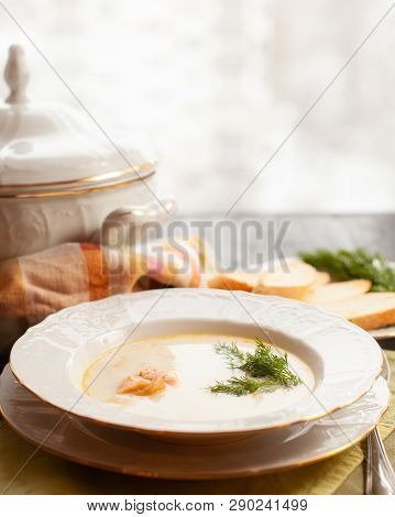 Creamy Fish Soup With Salmon, Potatoes And Dill On Woodwn Table Nearby Window