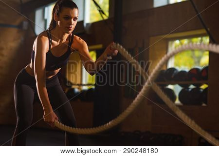 Fit, Sporty And Athletic Sportswoman Working In A Gym. Woman Training Using Battle Ropes. Sports, At