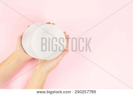 Woman Holding Silicone Implants For Breast Augmentation On Color Background, Top View With Space For