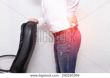 A Man Holds His Back Holding An Office Chair Concept Of Back Pain, Pinched Nerve And Myofascial Synd