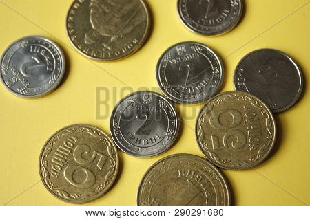 Ukrainian Coins Isolated On Yellow Background. Close-up Coins Are Located In The Center Of The Frame