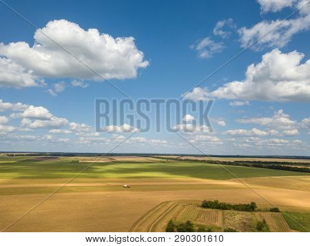 Bird's eye view of rural countryscape with clouds on a blue sky background in a summer sunny day. Aerial view from drone.