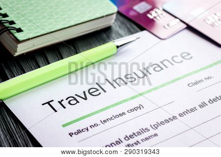Traveling Concept With Insurance Application On Wooden Table