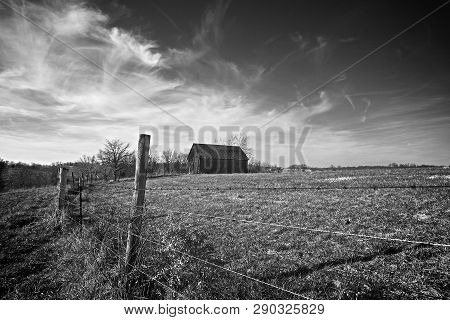 Old Tobacco Barn Sits Along Barbed Wire Fence.